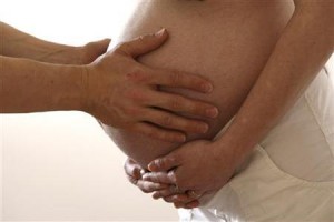 A husband touches his wife's stomach in the last stages of her pregnancy in Bordeaux